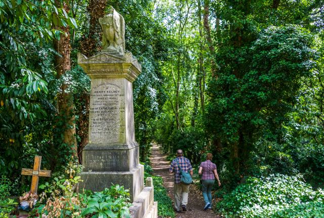 Roy and docent walk down path at Highgate Cemetery in London.