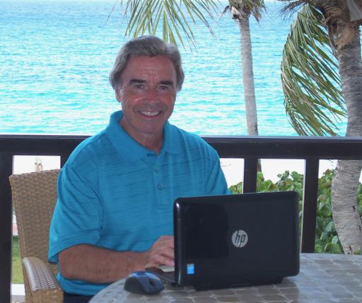 Tim Cotroneo sitting with his laptop in Anguilla.